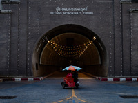 A seller with a colorful umbrella motorcycle cart enters Betong Mongkollit Tunnel in Betong, Yala Province, Thailand, on October 21, 2024. (