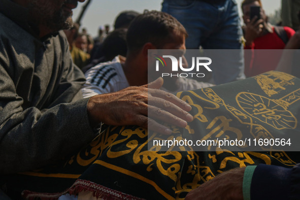 Relatives and mourners grieve next to the body of Kashmiri doctor Shahnawaz Dar in Nadigam village southwest of Srinagar, Jammu and Kashmir,...