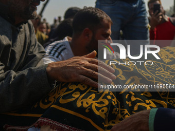 Relatives and mourners grieve next to the body of Kashmiri doctor Shahnawaz Dar in Nadigam village southwest of Srinagar, Jammu and Kashmir,...