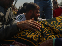 Relatives and mourners grieve next to the body of Kashmiri doctor Shahnawaz Dar in Nadigam village southwest of Srinagar, Jammu and Kashmir,...