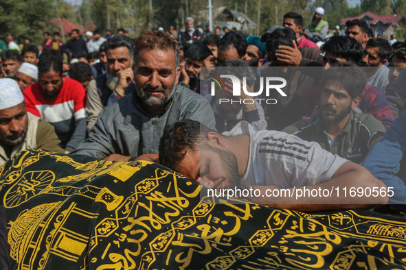 Relatives and mourners grieve next to the body of Kashmiri doctor Shahnawaz Dar in Nadigam village southwest of Srinagar, Jammu and Kashmir,...