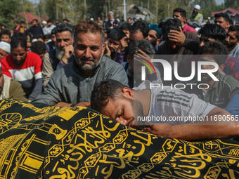 Relatives and mourners grieve next to the body of Kashmiri doctor Shahnawaz Dar in Nadigam village southwest of Srinagar, Jammu and Kashmir,...