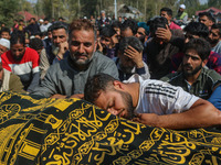 Relatives and mourners grieve next to the body of Kashmiri doctor Shahnawaz Dar in Nadigam village southwest of Srinagar, Jammu and Kashmir,...