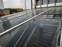 An elderly Iranian man climbs stairs while leaving an underground pedestrian way near a market (bazaar) in the historical city of Tabriz, lo...