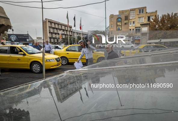 An Iranian worker carries goods in a plastic bag while passing an avenue near a market (bazaar) in the historical city of Tabriz, located 62...