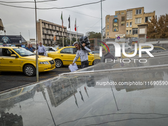 An Iranian worker carries goods in a plastic bag while passing an avenue near a market (bazaar) in the historical city of Tabriz, located 62...