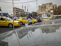 An Iranian worker carries goods in a plastic bag while passing an avenue near a market (bazaar) in the historical city of Tabriz, located 62...