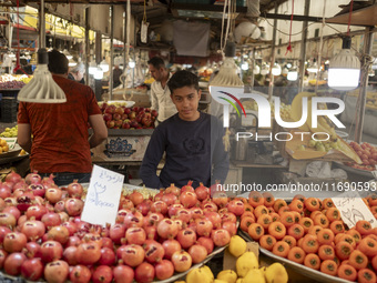 A young Iranian salesman stands at a fruit stand at a bazaar in the historical city of Tabriz, Iran, on October 17, 2024. (