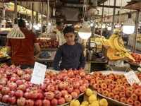 A young Iranian salesman stands at a fruit stand at a bazaar in the historical city of Tabriz, Iran, on October 17, 2024. (