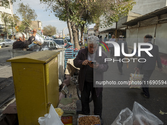 An Iranian vendor checks a card reader while standing outside a bazaar in the historical city of Tabriz, located 624 km (388 miles) northwes...