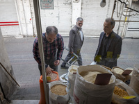 An Iranian shopkeeper checks legumes placed outside his shop at a bazaar in the historical city of Tabriz, Iran, on October 17, 2024. (