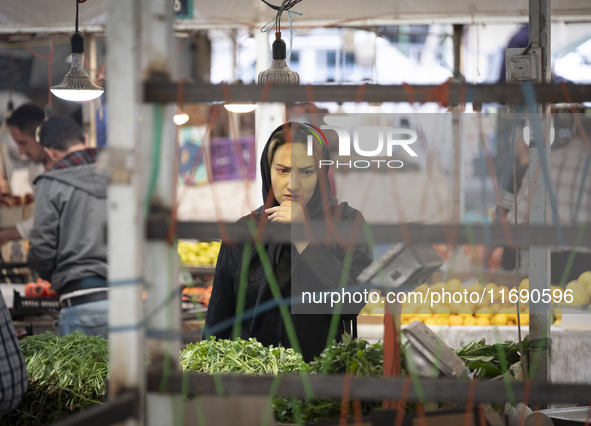 An Iranian woman looks at vegetables while shopping at a bazaar in the historical city of Tabriz, located 624 km northwest of Tehran in the...