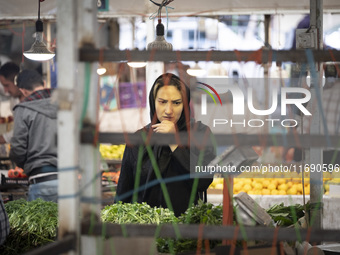 An Iranian woman looks at vegetables while shopping at a bazaar in the historical city of Tabriz, located 624 km northwest of Tehran in the...