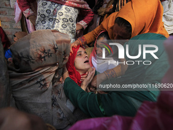 In Budgam, Kashmir, India, on October 21, 2024, a sister mourns over the dead body of Doctor Shahnawaz Ahmad Dar during his funeral ceremony...