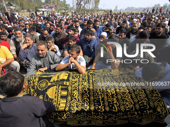 People gather near the body of Doctor Shahnawaz Ahmad Dar during his funeral ceremony at his native village in Nadigam in central Kashmir's...