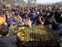 People gather near the body of Doctor Shahnawaz Ahmad Dar during his funeral ceremony at his native village in Nadigam in central Kashmir's...