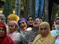 Relatives mourn over the body of Doctor Shahnawaz Ahmad Dar during his funeral ceremony at his native village in Nadigam in central Kashmir'...