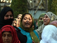 Relatives mourn over the body of Doctor Shahnawaz Ahmad Dar during his funeral ceremony at his native village in Nadigam in central Kashmir'...