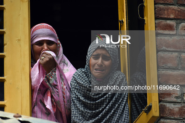 Relatives mourn over the body of Doctor Shahnawaz Ahmad Dar during his funeral ceremony at his native village in Nadigam in central Kashmir'...