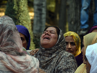 Women mourn over the body of Doctor Shahnawaz Ahmad Dar during his funeral ceremony in his native village in Nadigam in central Kashmir's Bu...