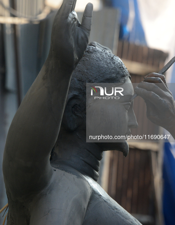 An artist works on a semi-finished clay idol of the Hindu goddess Kali in Siliguri, India, on October 21, 2024. The worship of the Hindu dei...