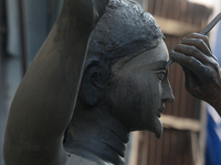 An artist works on a semi-finished clay idol of the Hindu goddess Kali in Siliguri, India, on October 21, 2024. The worship of the Hindu dei...