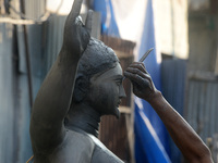 An artist works on a semi-finished clay idol of the Hindu goddess Kali in Siliguri, India, on October 21, 2024. The worship of the Hindu dei...