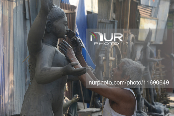 An artist works on a semi-finished clay idol of the Hindu goddess Kali in Siliguri, India, on October 21, 2024. The worship of the Hindu dei...