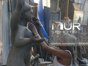 An artist works on a semi-finished clay idol of the Hindu goddess Kali in Siliguri, India, on October 21, 2024. The worship of the Hindu dei...