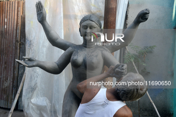 An artist works on a semi-finished clay idol of the Hindu goddess Kali in Siliguri, India, on October 21, 2024. The worship of the Hindu dei...