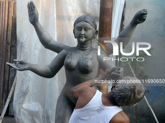 An artist works on a semi-finished clay idol of the Hindu goddess Kali in Siliguri, India, on October 21, 2024. The worship of the Hindu dei...