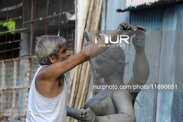 An artist works on a semi-finished clay idol of the Hindu goddess Kali in Siliguri, India, on October 21, 2024. The worship of the Hindu dei...