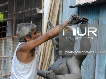 An artist works on a semi-finished clay idol of the Hindu goddess Kali in Siliguri, India, on October 21, 2024. The worship of the Hindu dei...