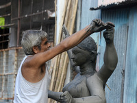 An artist works on a semi-finished clay idol of the Hindu goddess Kali in Siliguri, India, on October 21, 2024. The worship of the Hindu dei...