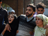 In Budgam, Kashmir, India, on October 21, 2024, Brother (C) mourns over the dead body of Doctor Shahnawaz Ahmad Dar during his funeral cerem...