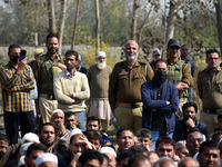 Indian policemen are seen near the body of Doctor Shahnawaz Ahmad Dar during his funeral ceremony at his native village in Nadigam in centra...