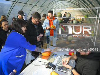 A vendor weighs a pumpkin during a pumpkin festival in Warsaw, Poland, on October 20, 2024. (