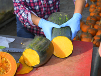 A vendor cut a Long of Naples squash during a pumpkin festival in Warsaw, Poland on Oct. 20, 2024.  (