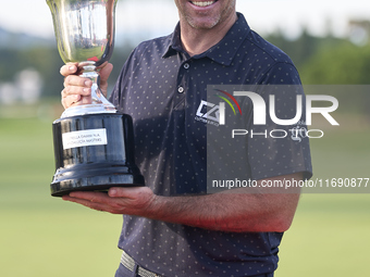 Julien Guerrier of France poses with the trophy on the 18th green after winning a nine-hole play-off on day four of the Estrella Damm N.A. A...