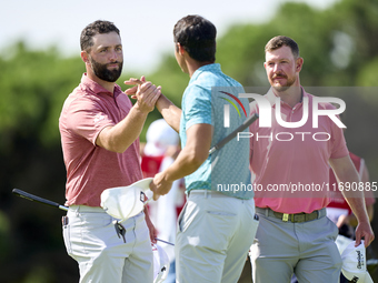 Jon Rahm of Spain greets Jacques Kruyswijk of South Africa and Johannes Veerman of the USA at the end of day four of the Estrella Damm N.A....