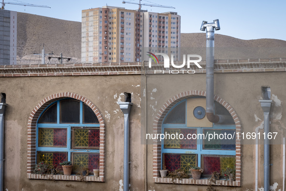 A housing complex is visible behind an Iranian traditional restaurant in the southern suburb of the historical city of Tabriz, located 624 k...