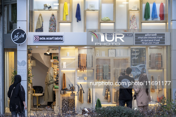 Iranian people look at scarves decorated in a scarf shop window in the historical city of Tabriz, located 624 km (388 miles) northwest of Te...