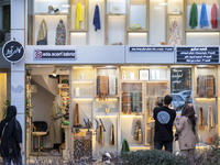 Iranian people look at scarves decorated in a scarf shop window in the historical city of Tabriz, located 624 km (388 miles) northwest of Te...