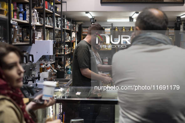 An Iranian barista prepares coffee for his clients in the historical city of Tabriz, Iran, on October 17, 2024. 