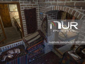 An Iranian man looks at an old Persian handwoven rug at a cultural center in the historical city of Tabriz, located 624 km (388 miles) north...