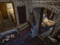 An Iranian man looks at an old Persian handwoven rug at a cultural center in the historical city of Tabriz, located 624 km (388 miles) north...