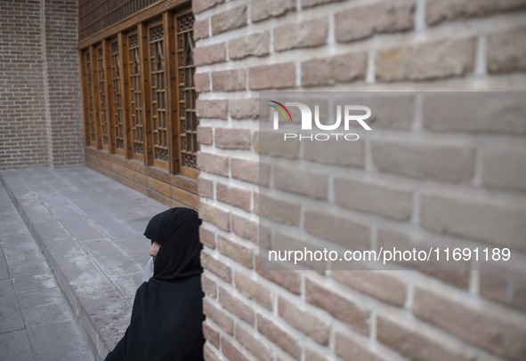 A veiled Iranian woman sits outside a mosque in the historical city of Tabriz, located 624 km (388 miles) northwest of Tehran in the Eastern...