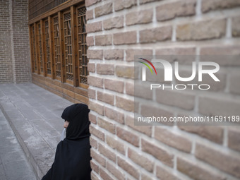 A veiled Iranian woman sits outside a mosque in the historical city of Tabriz, located 624 km (388 miles) northwest of Tehran in the Eastern...