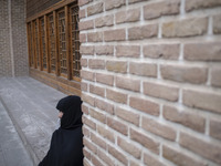 A veiled Iranian woman sits outside a mosque in the historical city of Tabriz, located 624 km (388 miles) northwest of Tehran in the Eastern...