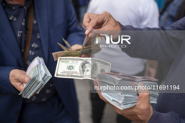 Iranian street money changers hold USD banknotes while standing on a sidewalk in the historical city of Tabriz, located 624 km (388 miles) n...